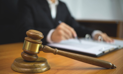 A personal injury lawyer at a desk reviewing documents in an open binder for a case.