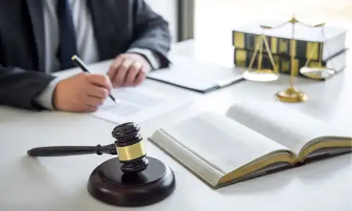 A lawyer with open law books preparing a personal injury case for a client.