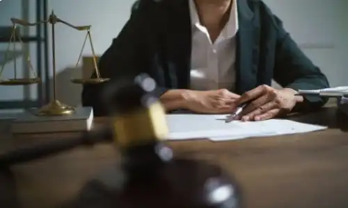 A car accident lawyer discusses a police report with a client in her Fresno office.