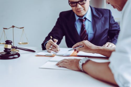 A California immigration lawyer meets with a client in a modern law office.